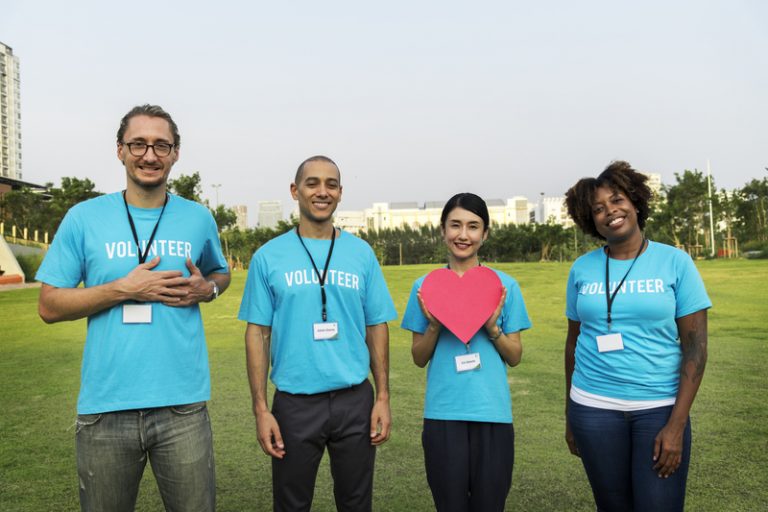 Group of volunteers holding a heart to show support and help for local communities